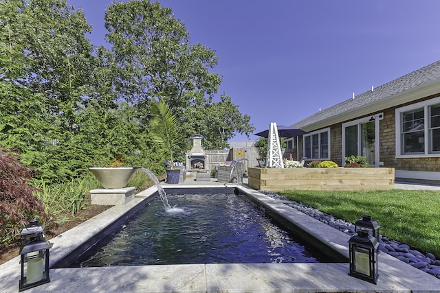 view of pool featuring exterior fireplace