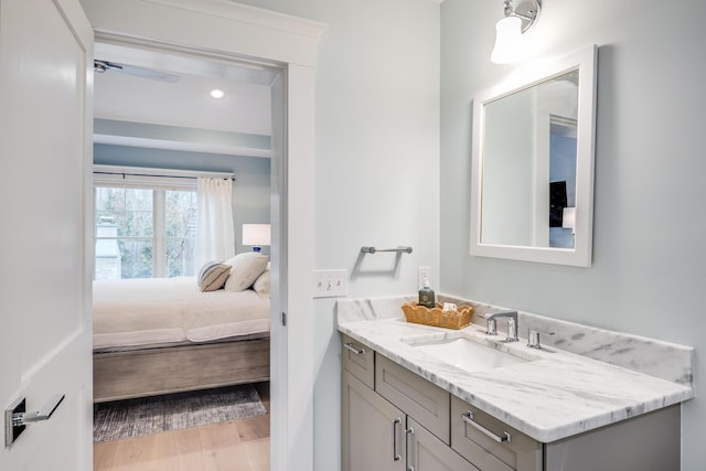 ensuite bathroom with ensuite bathroom, wood finished floors, and vanity