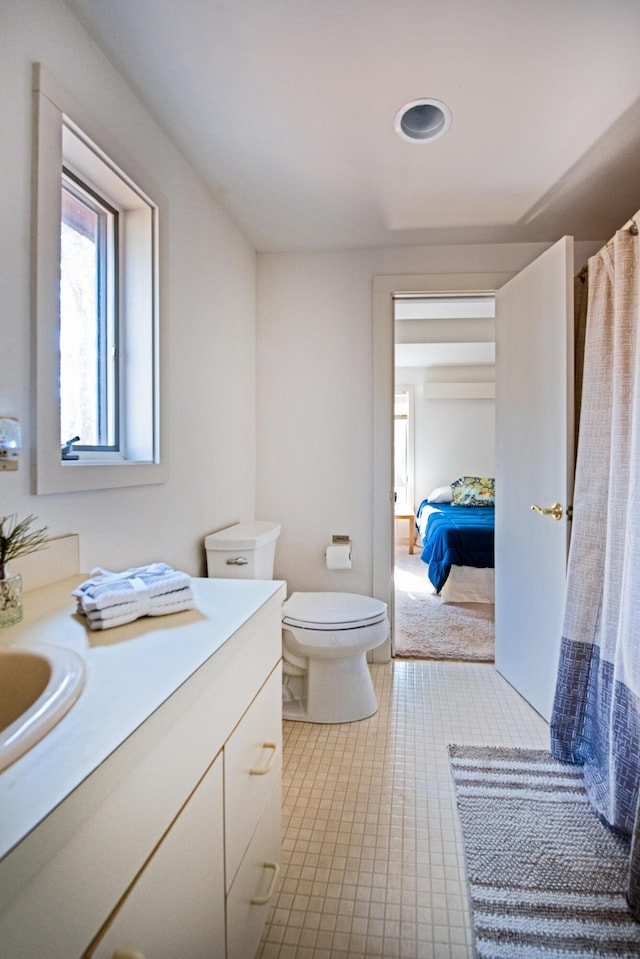 ensuite bathroom featuring toilet, vanity, and ensuite bath