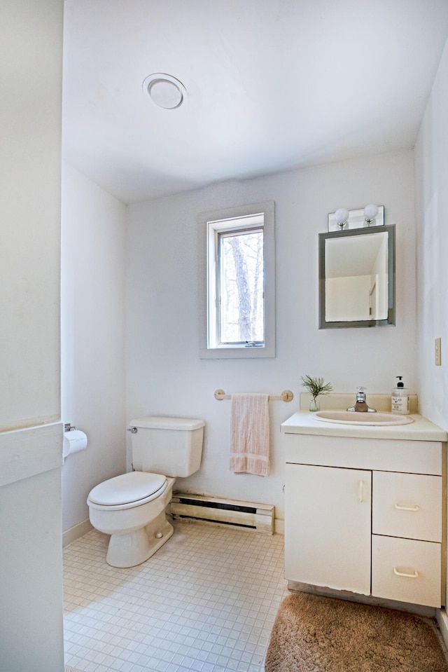 bathroom with toilet, baseboard heating, vanity, and baseboards