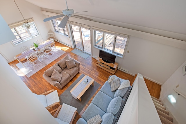 living room featuring stairs, a baseboard radiator, and wood finished floors