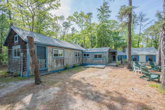 92 John Joseph Rd, Harwich, MA 02645 - back of house featuring a chimney and roof with shingles