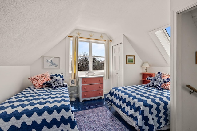 bedroom with lofted ceiling with skylight, a closet, and a textured ceiling