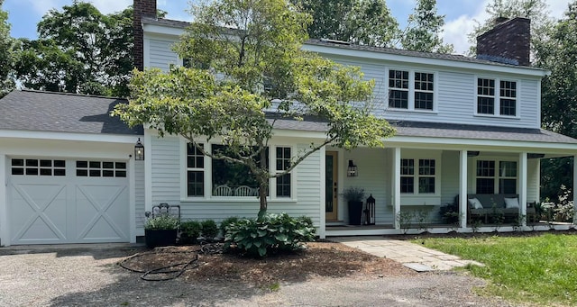 view of front of house featuring a garage, covered porch, a chimney, and roof with shingles