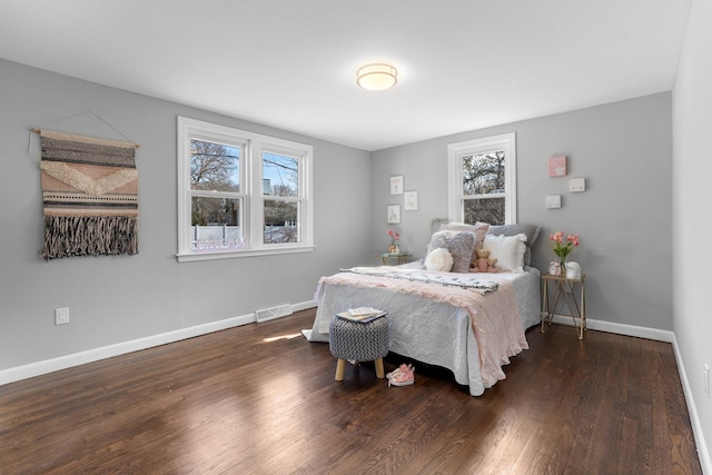 bedroom featuring visible vents, baseboards, and wood finished floors