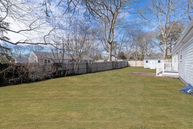 view of yard featuring a fenced backyard, a storage unit, and an outdoor structure