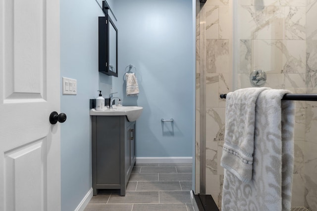 full bath featuring a shower stall, baseboards, and vanity