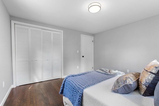 bedroom with a closet, baseboards, and wood finished floors