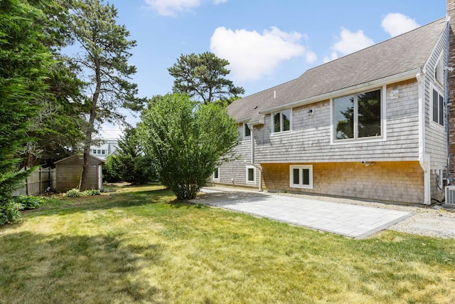 3 Waterside Dr, North Falmouth, MA 02556 - rear view of house with a patio area, a yard, a shingled roof, and a shed