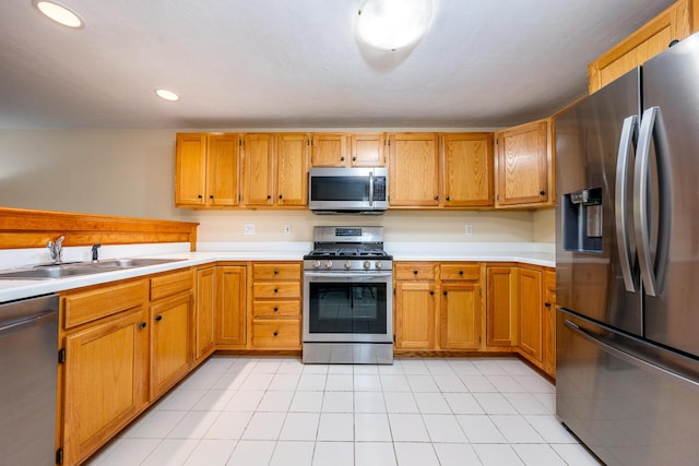 kitchen with stainless steel appliances, light tile patterned flooring, and sink