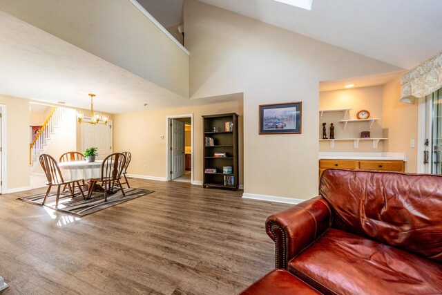 living room with an inviting chandelier, dark hardwood / wood-style floors, and high vaulted ceiling