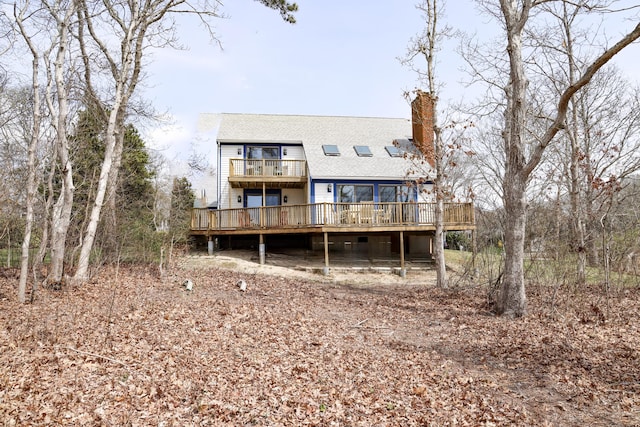 15 Beach St, East Falmouth, MA 02536 - back of property with a chimney, a wooden deck, a shingled roof, and a balcony