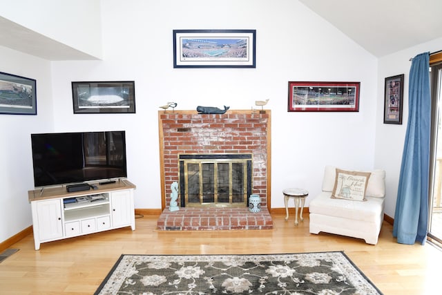 15 Beach St, East Falmouth, MA 02536 - living room featuring wood finished floors, a brick fireplace, and vaulted ceiling