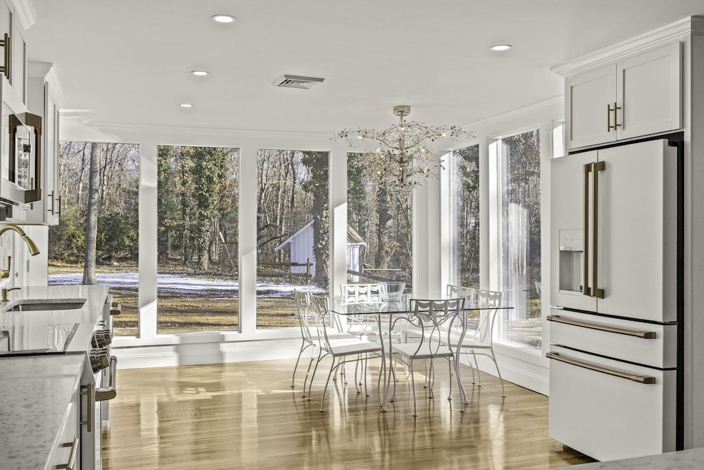 sunroom featuring sink and a notable chandelier