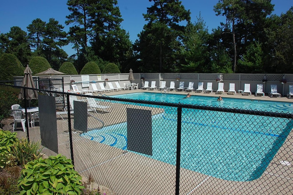pool with a patio area and fence