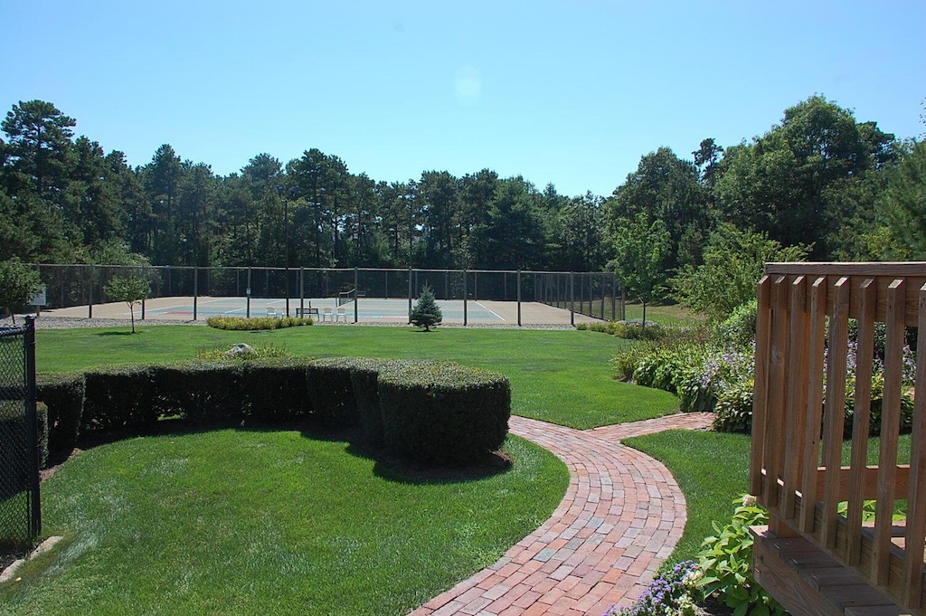 view of yard featuring fence and a tennis court