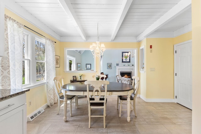 11 White Oak Trl, Centerville, MA 02632 - dining space featuring beamed ceiling, baseboards, a chandelier, a lit fireplace, and wood ceiling