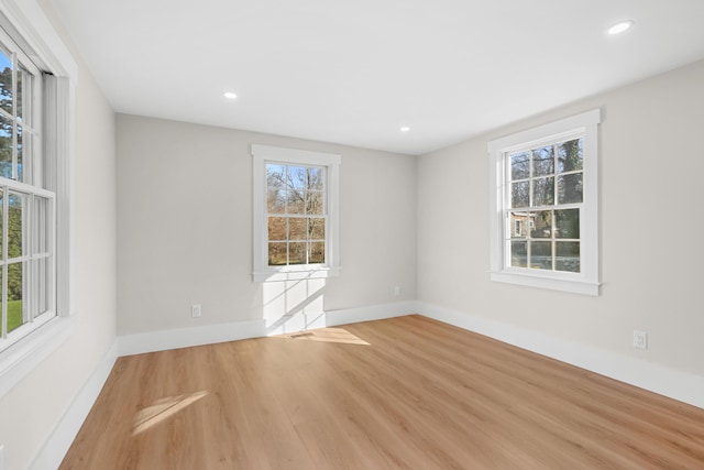 empty room featuring a healthy amount of sunlight and hardwood / wood-style floors