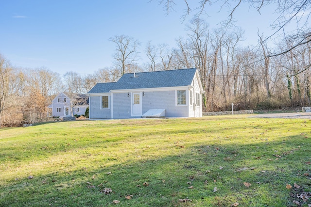 rear view of property featuring a yard