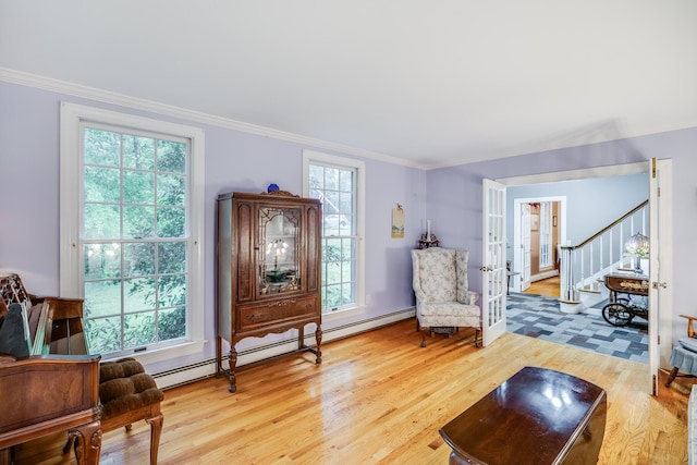 43 Owl Pond Rd, Brewster, MA 02631 - living room with wood finished floors, plenty of natural light, crown molding, stairway, and a baseboard radiator