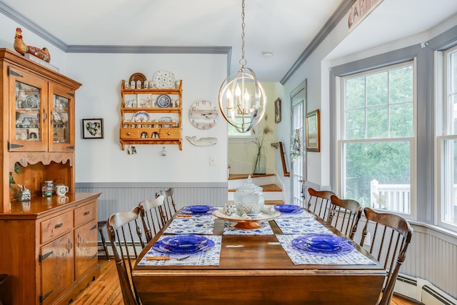43 Owl Pond Rd, Brewster, MA 02631 - dining space with light wood-style flooring, a chandelier, plenty of natural light, ornamental molding, and a wainscoted wall