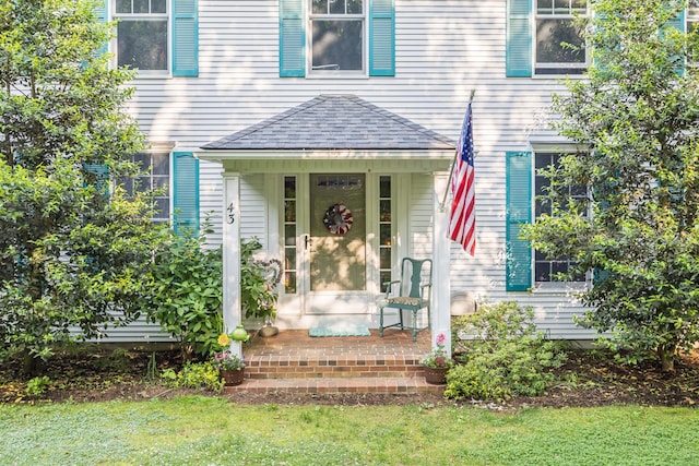 43 Owl Pond Rd, Brewster, MA 02631 - view of exterior entry with a shingled roof and a yard