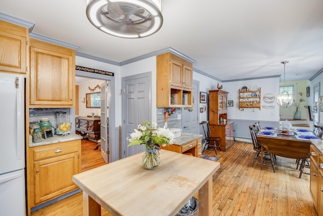 43 Owl Pond Rd, Brewster, MA 02631 - kitchen with freestanding refrigerator, light wood-type flooring, a chandelier, light countertops, and a wainscoted wall