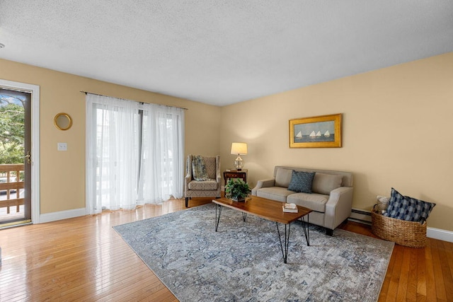 800 Bearses Way Unit 1Wd, Hyannis, MA 02601 - living room with wood-type flooring, a baseboard radiator, and a textured ceiling