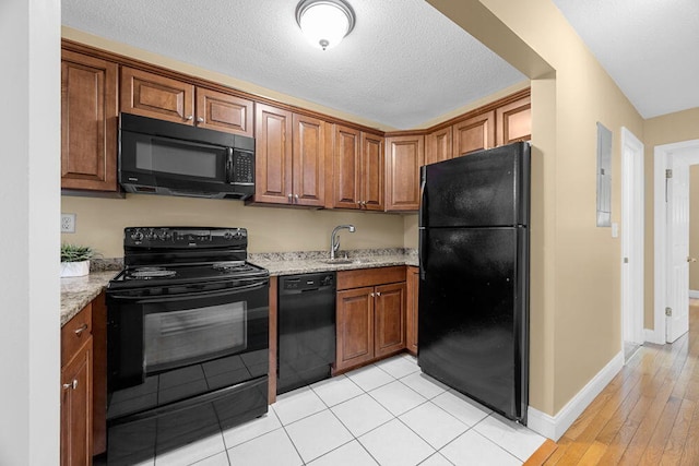 800 Bearses Way Unit 1Wd, Hyannis, MA 02601 - kitchen featuring black appliances, light stone countertops, brown cabinets, light wood-style flooring, and a textured ceiling
