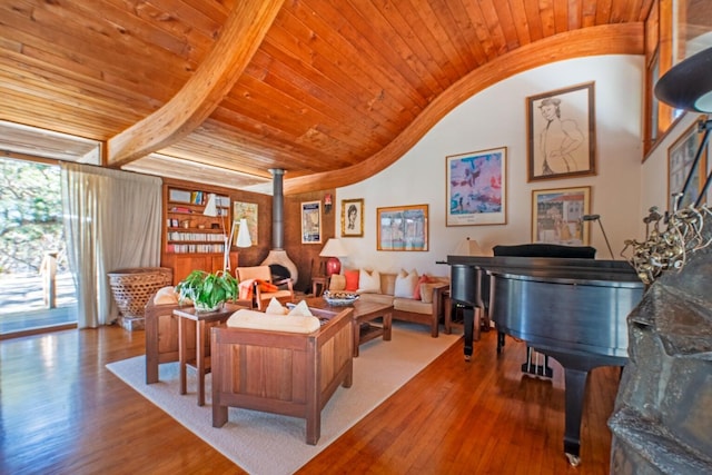 office with vaulted ceiling with beams, wood-type flooring, wooden ceiling, and a wood stove