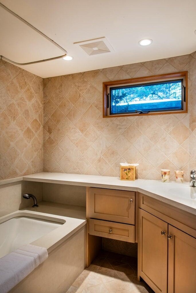 bathroom with tile patterned flooring, vanity, plenty of natural light, and tile walls