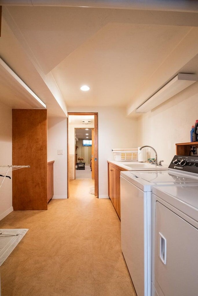 washroom with washer and dryer, sink, and cabinets