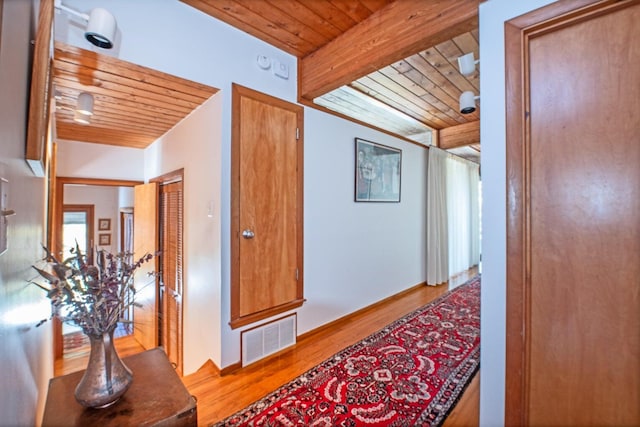 corridor with beam ceiling, hardwood / wood-style flooring, and wood ceiling