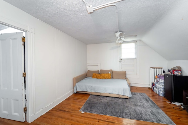 352 Bishop St, Framingham, MA 01702 - bedroom featuring radiator heating unit, wood finished floors, lofted ceiling, a textured ceiling, and a ceiling fan