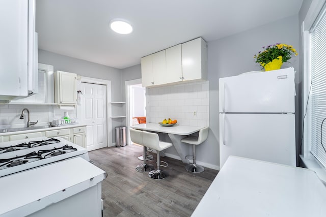 352 Bishop St, Framingham, MA 01702 - kitchen featuring freestanding refrigerator, a sink, decorative backsplash, and white cabinetry