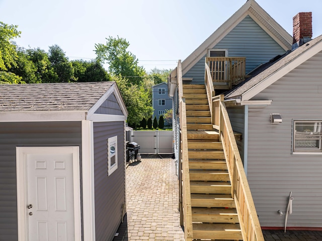 352 Bishop St, Framingham, MA 01702 - view of home's exterior featuring stairs, roof with shingles, fence, a gate, and a patio area