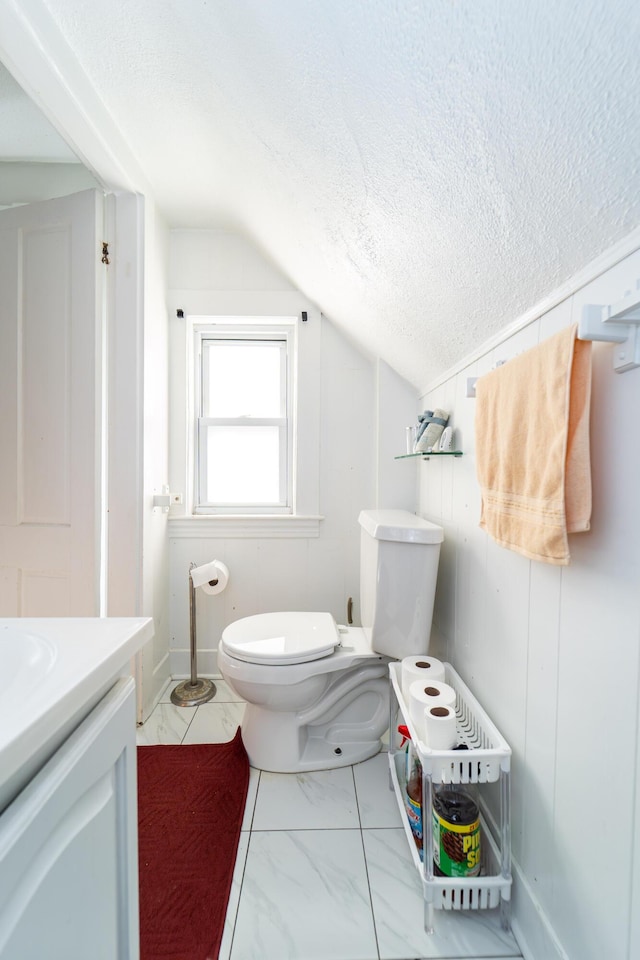 352 Bishop St, Framingham, MA 01702 - bathroom featuring vaulted ceiling, toilet, marble finish floors, vanity, and a textured ceiling