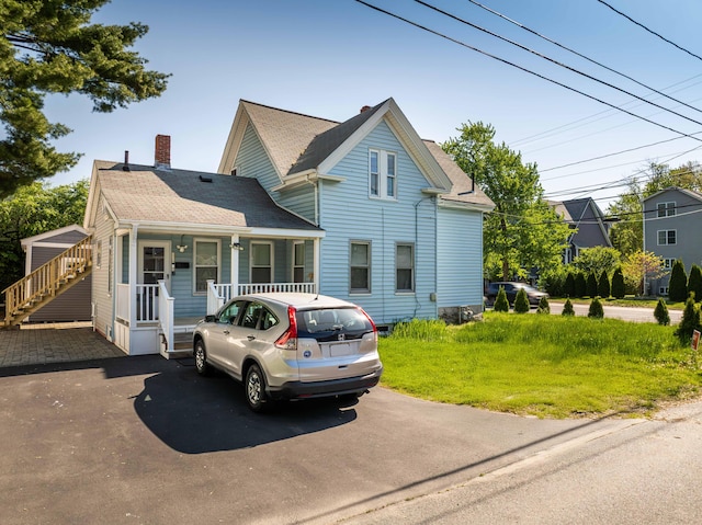 352 Bishop St, Framingham, MA 01702 - view of front of property with a porch, a chimney, a shingled roof, and driveway