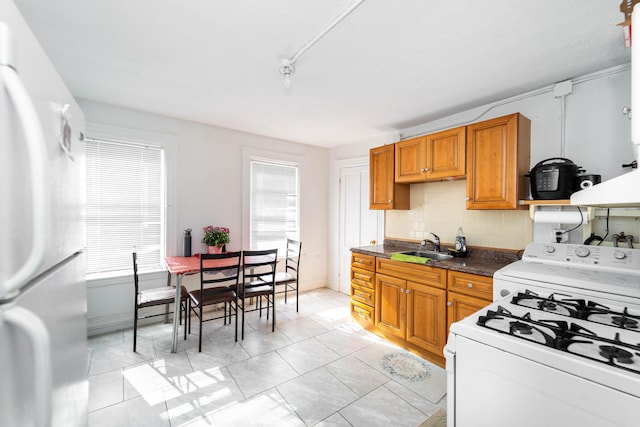 352 Bishop St, Framingham, MA 01702 - kitchen with white appliances, tasteful backsplash, brown cabinetry, and a sink
