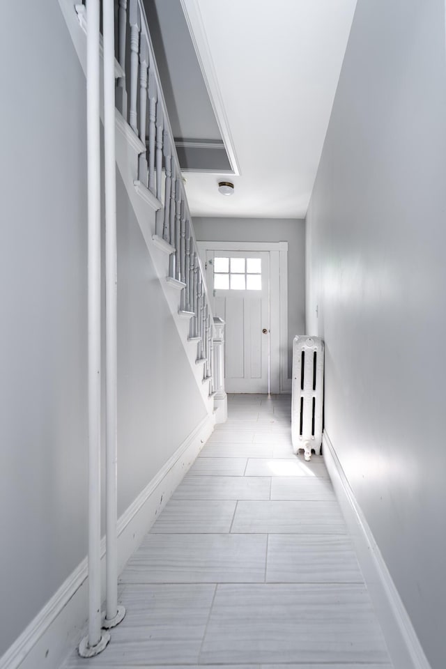 352 Bishop St, Framingham, MA 01702 - foyer with radiator heating unit, stairway, and baseboards