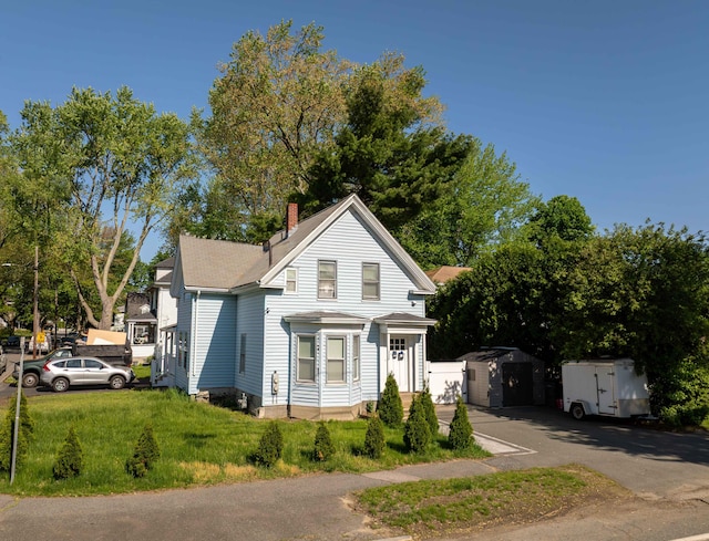 352 Bishop St, Framingham, MA 01702 - view of front of property with a chimney, roof with shingles, and a front lawn