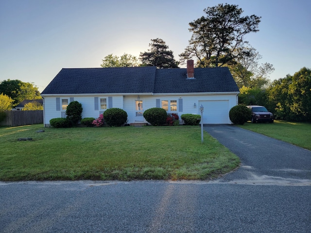 ranch-style house with a front lawn, driveway, and fence