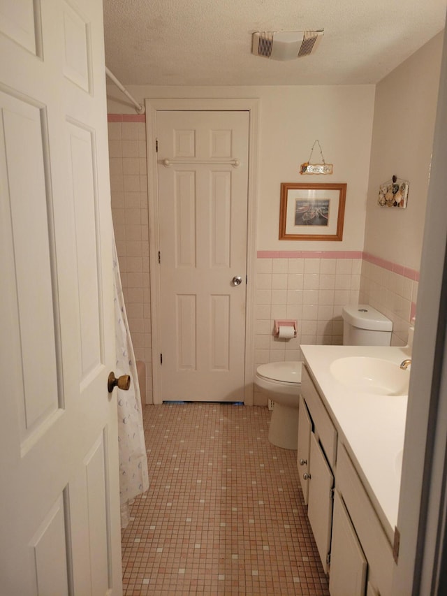 115 Captain Chase Rd, South Yarmouth, MA 02664 - full bathroom with tile walls, toilet, vanity, a shower with curtain, and a textured ceiling