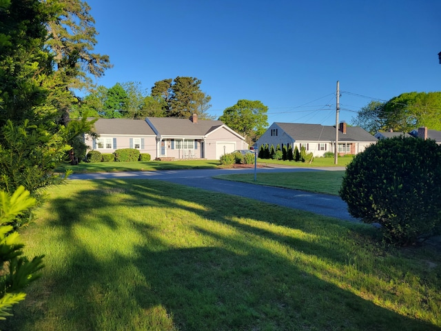 ranch-style home featuring a front lawn and a chimney