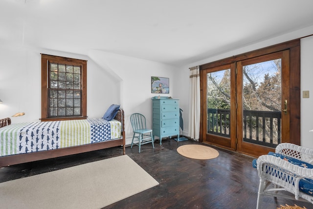 bedroom featuring access to outside, multiple windows, and wood finished floors