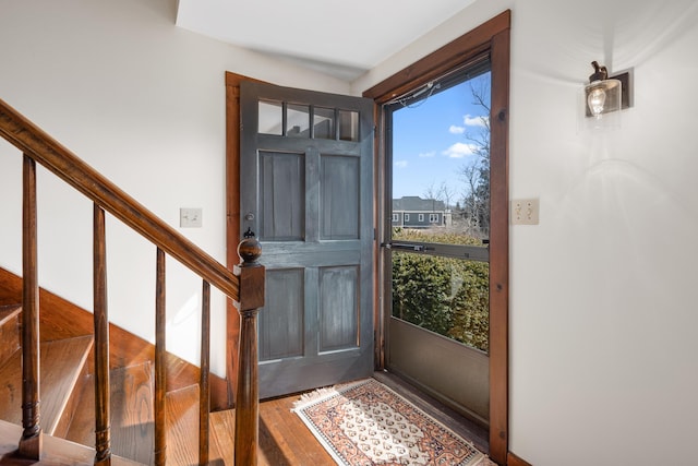 entryway with wood finished floors and stairs