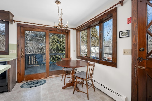 dining area featuring a baseboard heating unit, a notable chandelier, and a healthy amount of sunlight