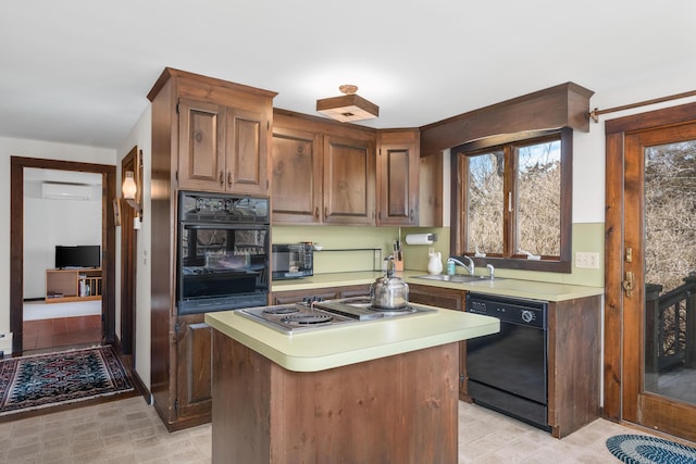 kitchen with black appliances, a wall mounted AC, a sink, light countertops, and light floors