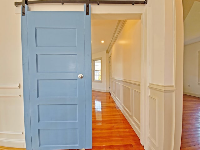 23 Old Barnstable Rd, East Falmouth, MA 02536 - corridor with crown molding, a barn door, and hardwood / wood-style flooring