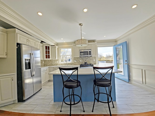 23 Old Barnstable Rd, East Falmouth, MA 02536 - kitchen featuring a kitchen breakfast bar, crown molding, appliances with stainless steel finishes, a center island, and light countertops